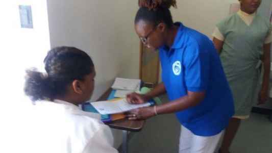 Mrs. Murray-John assists a RN on male orthopaedic during registration.